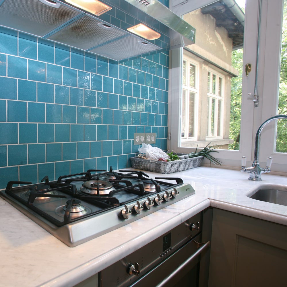 modern kitchen with a bright turquoise glazed square subway tile 